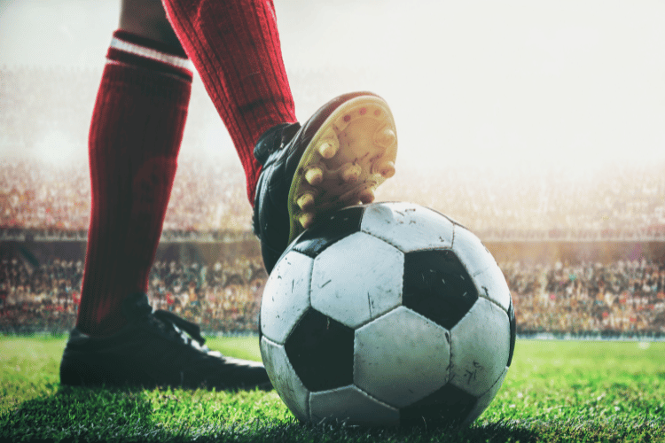 what is a second ball in football - Close-up of feet of football player tread on football for kick-off in the stadium