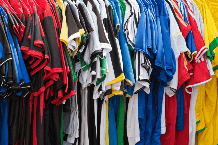 Colourful football shirts hanging together on a stand