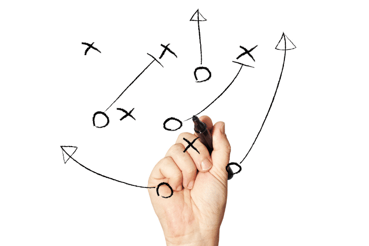 Hand drawing Xs and Os of game plan