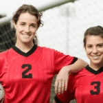 Smiling female soccer players wearing red shirts