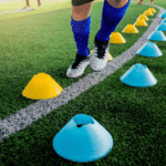Soccer player Jogging between cone markers on green artificial turf for soccer training