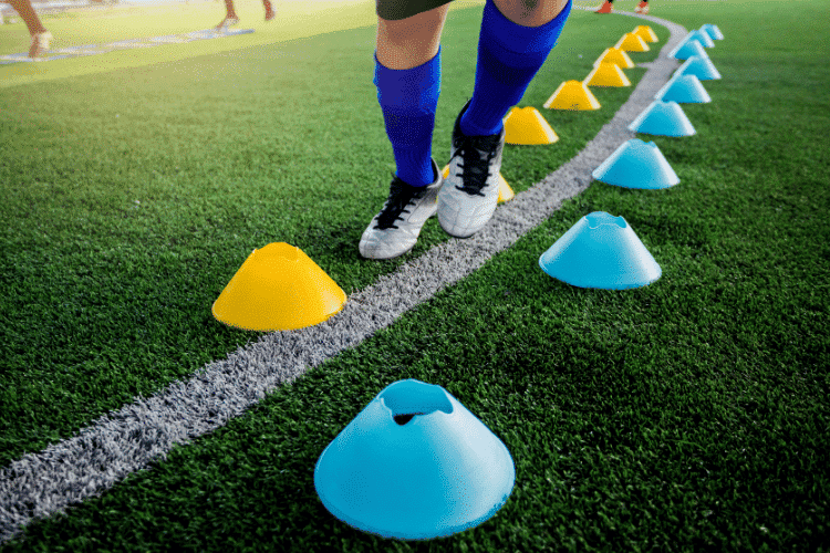 Soccer player Jogging between cone markers on green artificial turf for soccer training