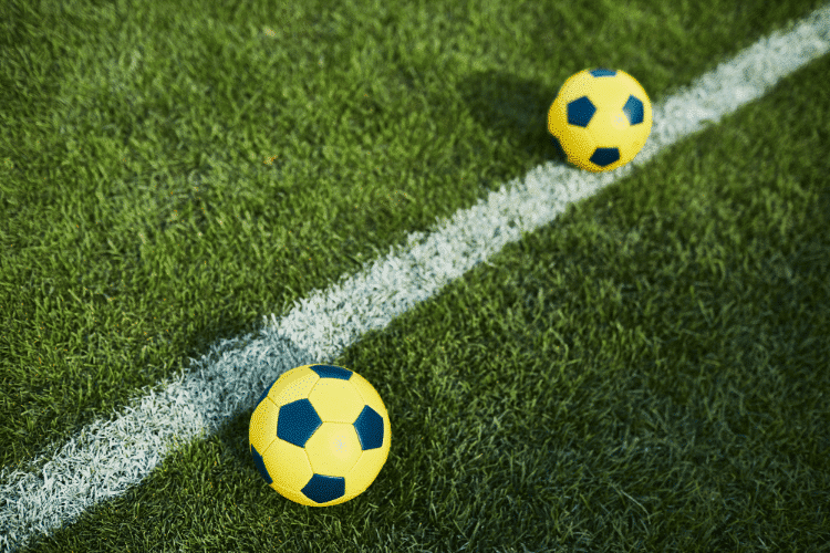 Top- view of two soccer balls on playground floor