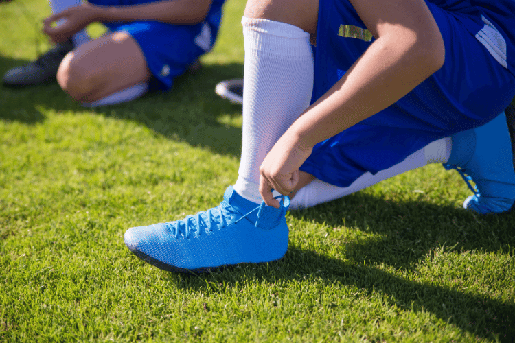 A player in blue Nike boots at football pitch