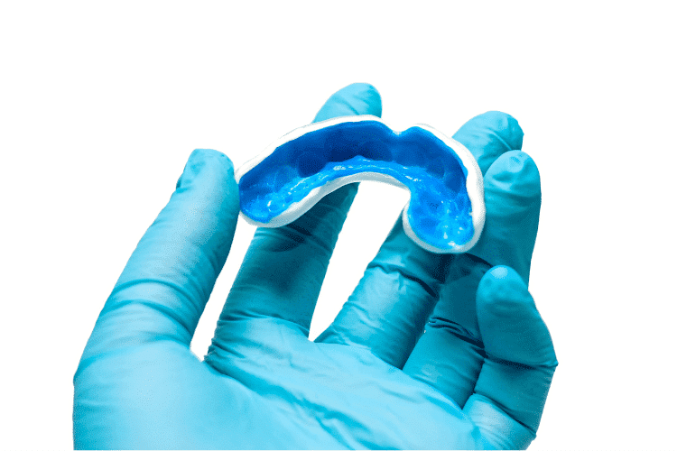 A white custom mouthguard in hand