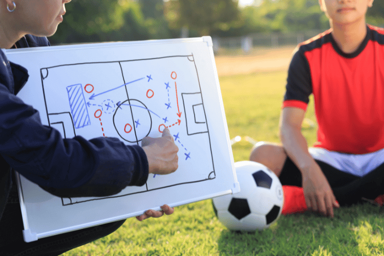 Coach training a tactic for a teenager football player