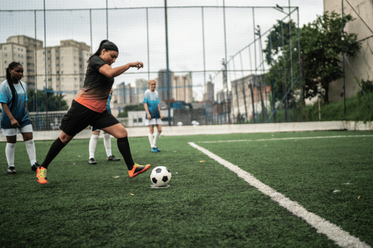 Female football player kick the ball at the penalty
