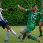 Female soccer players playing at a soccer field
