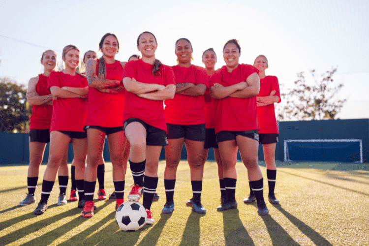 Portrait of smiling women football team training for football match