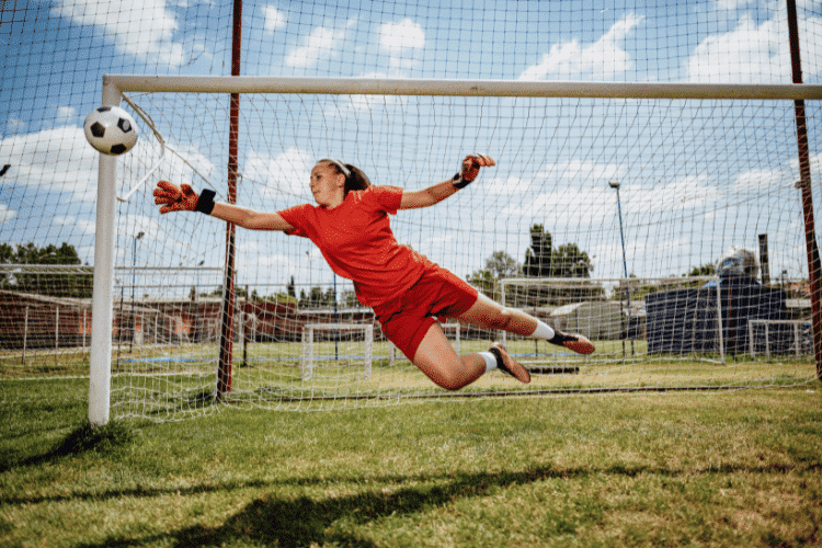 Football penalty kick with teen female goalkeeper