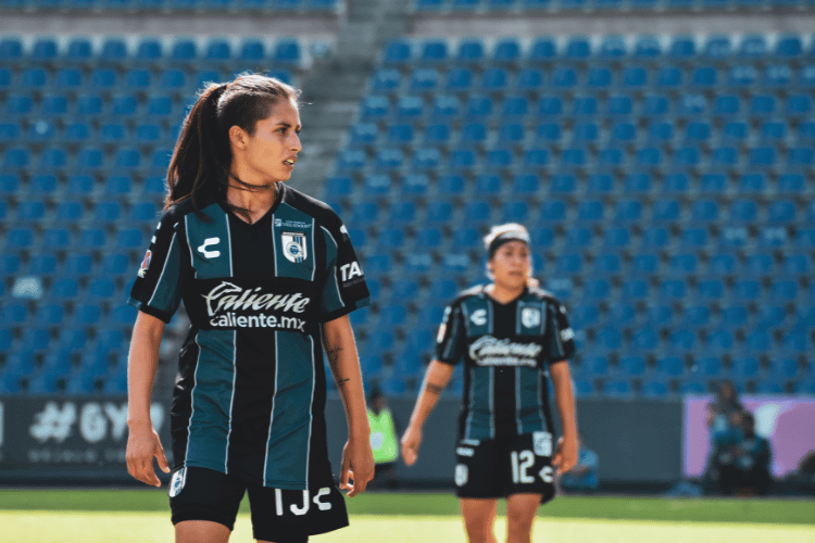 Two female football players playing at soccer field