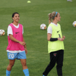 Two female soccer players wearing Nike jersey in training at soccer field