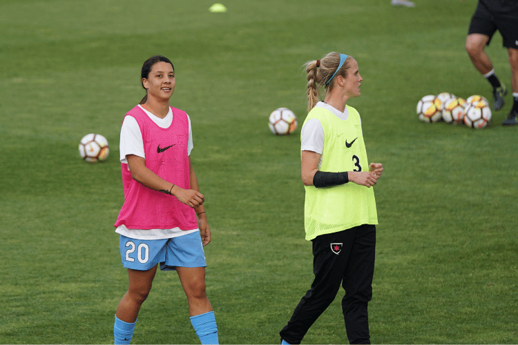 Two female soccer players wearing Nike jersey in training at soccer field