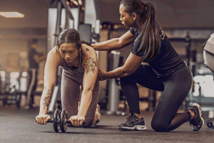 A young woman working out in the Gym with a female personal trainer