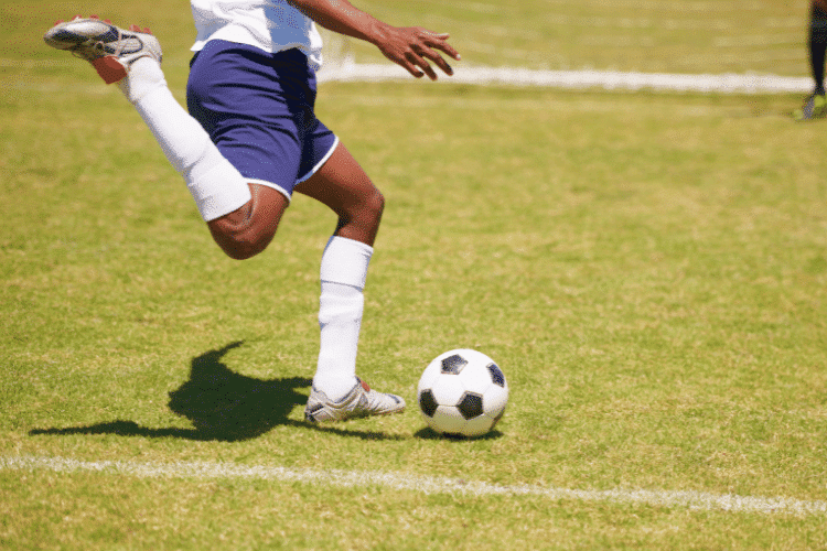 Close-up of a football player kicking a free kick