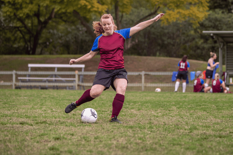 Female Soccer player kicking the ball