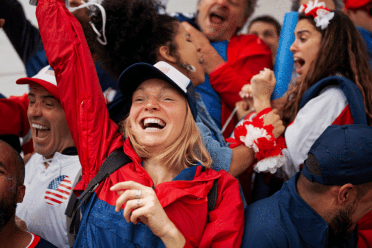 Young American woman cheering at stadium during USA national team football game