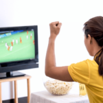 Young Asian Woman Watching Soccer Match on Tv and Cheering