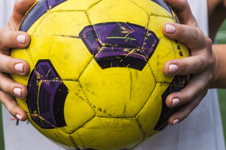 woman holding a football in her hands