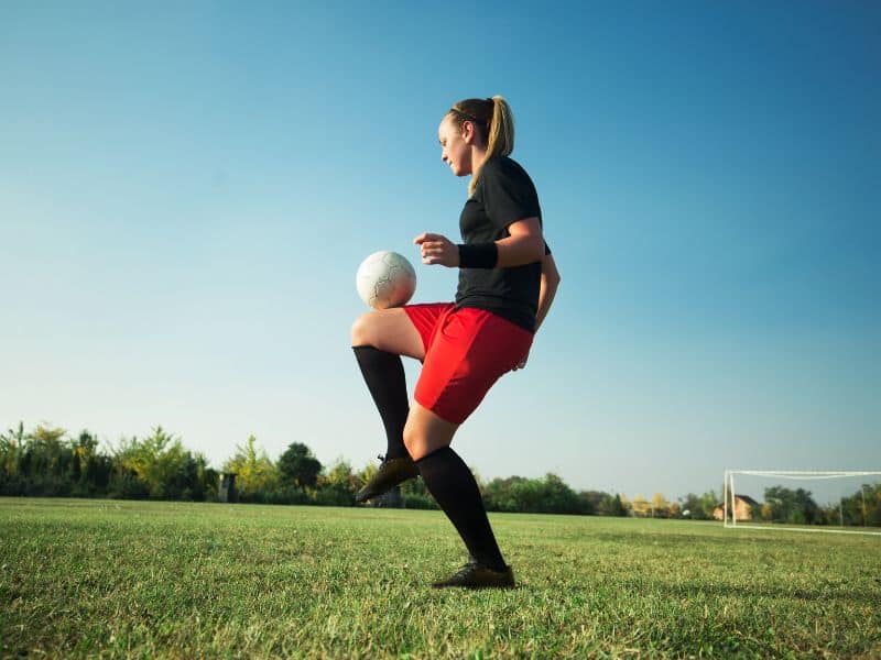 woman playing soccer practising alone